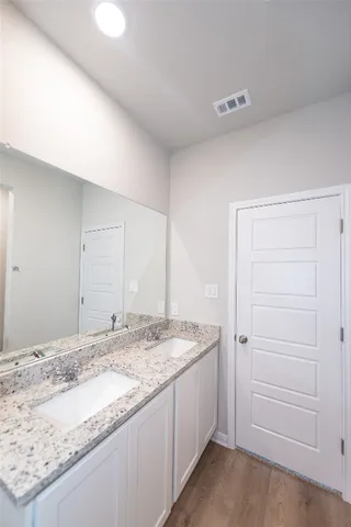 a bathroom with a granite countertop sink and a mirror