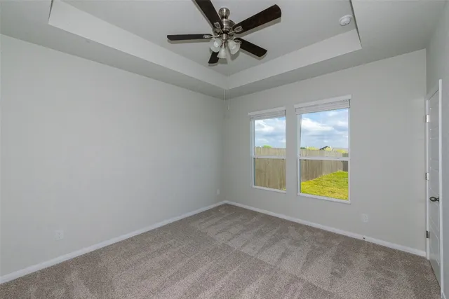 an empty room with a window and a ceiling fan