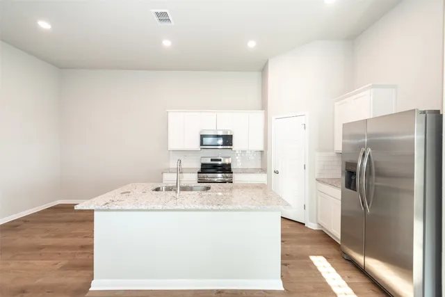 a kitchen with stainless steel appliances granite countertop a sink a refrigerator and a granite counter tops