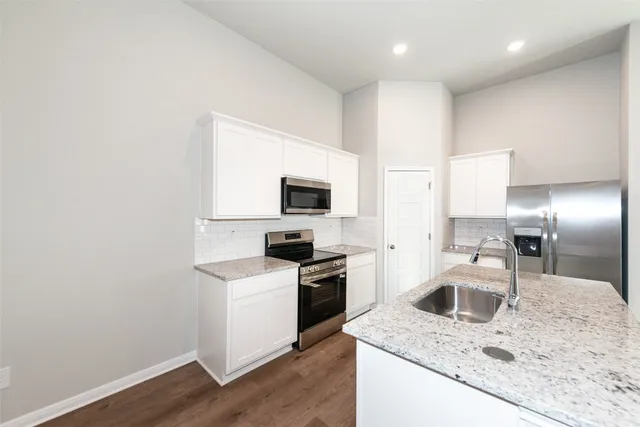 a kitchen with a sink a stove top oven and refrigerator