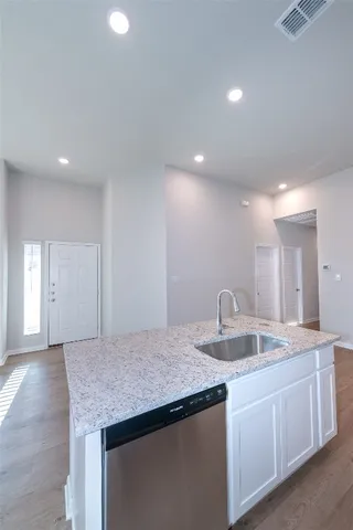 a kitchen with granite countertop kitchen island a sink appliances and a counter space