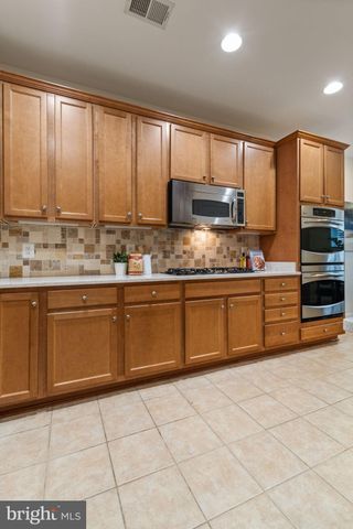 a kitchen with stainless steel appliances a sink window and cabinets