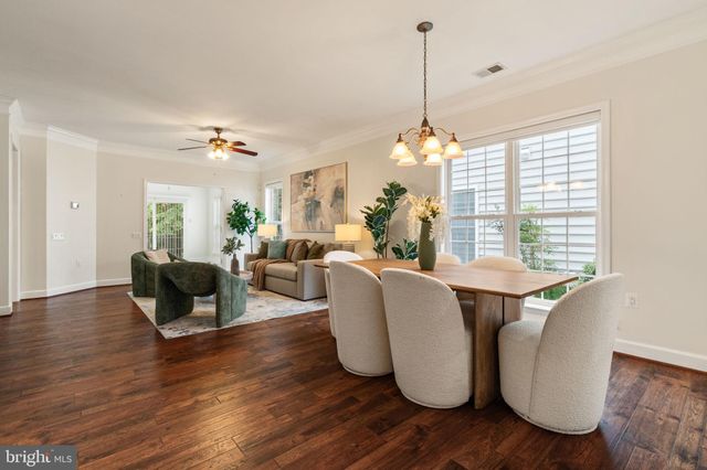 a living room with couches chairs and wooden floor