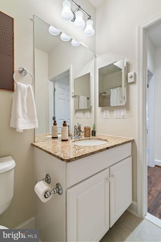 a bathroom with a granite countertop sink a toilet and a mirror