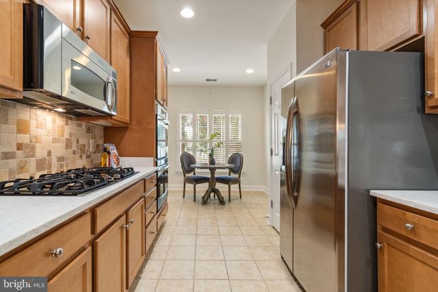 a kitchen with stainless steel appliances granite countertop a refrigerator a stove and a sink with granite countertops