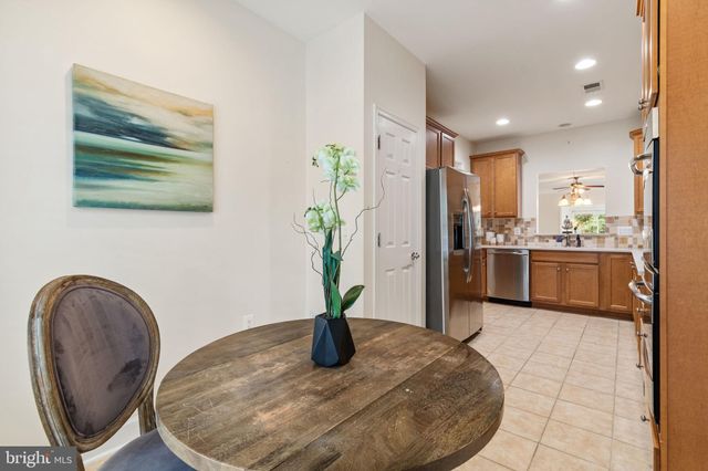 a view of a kitchen with kitchen island a counter top space cabinets stainless steel appliances and wooden floor