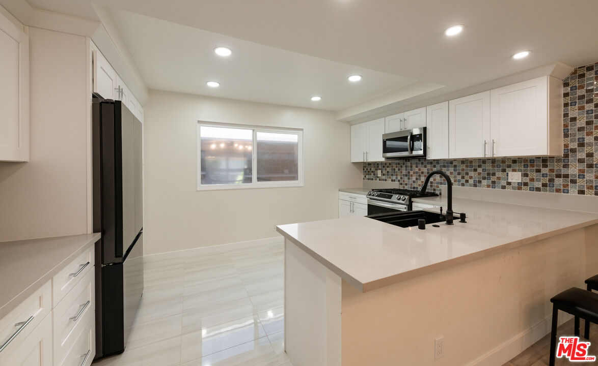 13206 Admiral Avenue, Unit F Marina del Rey, CA 90292 - Photo 6 of 21 a kitchen with sink refrigerator and microwave