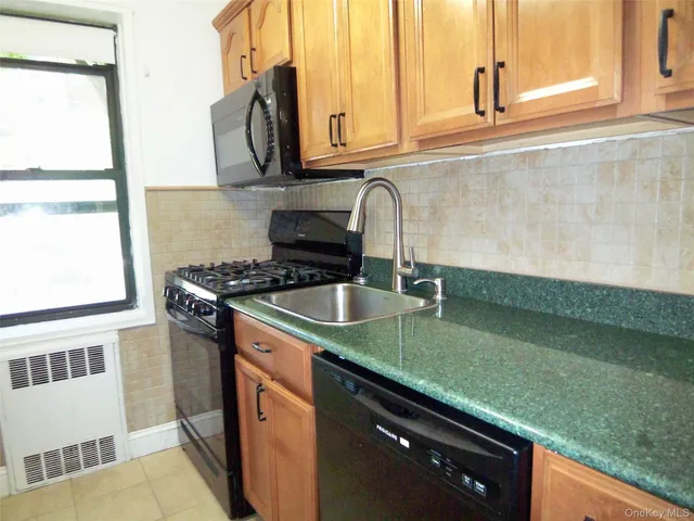 a kitchen with stainless steel appliances granite countertop a sink a stove and a microwave