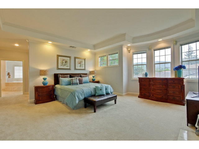 10171 Carmen Road Cupertino, CA 95014 - Photo 14 of 25 a spacious bedroom with a bed a couch and windows