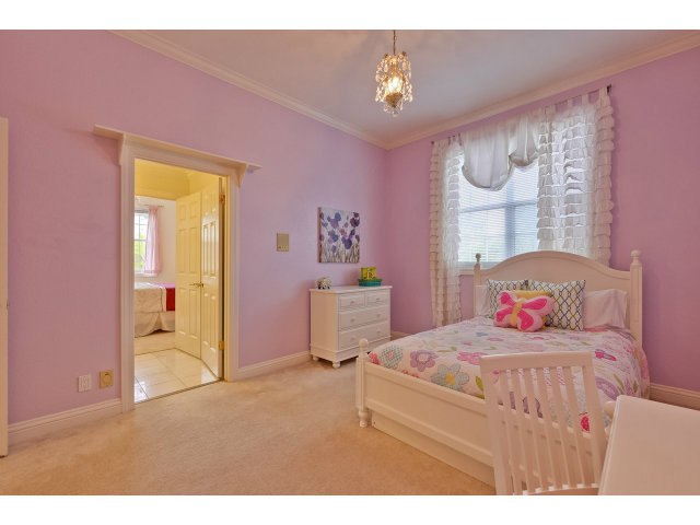 10171 Carmen Road Cupertino, CA 95014 - Photo 18 of 25 a bedroom with a bed and a chandelier