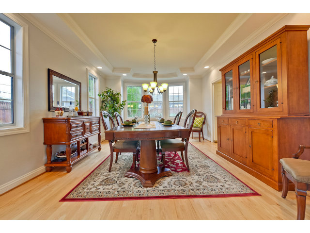 10171 Carmen Road Cupertino, CA 95014 - Photo 6 of 25 a dining room with furniture a rug a potted plant and a chandelier