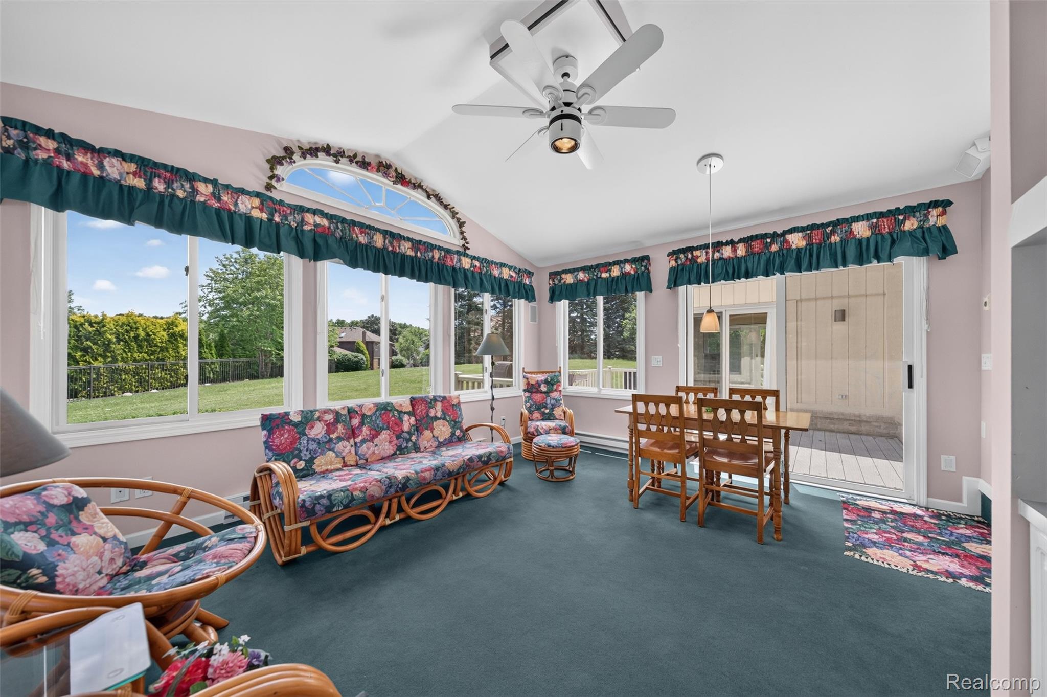 1236 Chaffer Drive Rochester, MI 48306 - Photo 22 of 76 Sunroom featuring a vaulted ceiling with a ceiling fan, multiple large windows, and a sliding glass door providing direct access to an outdoor deck