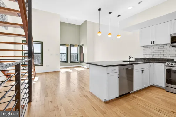 a kitchen with granite countertop a stove a sink and a wooden floors