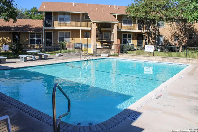 a view of a building with sitting area and swimming pool