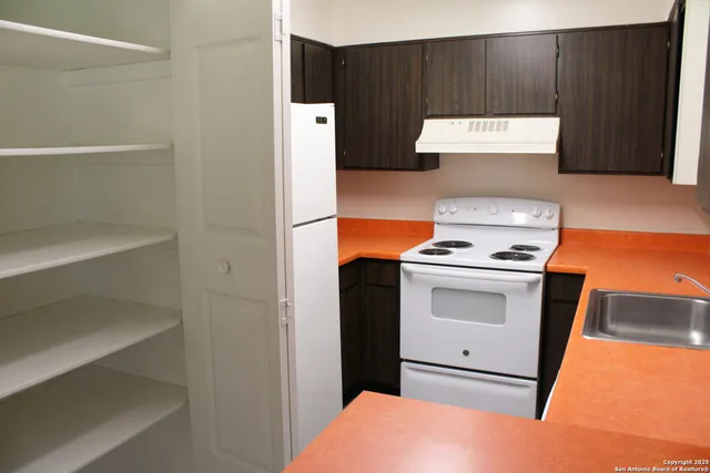 a kitchen with a refrigerator and a stove