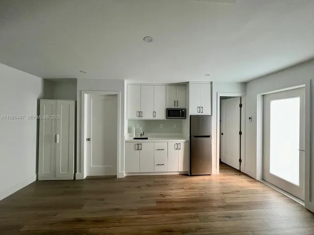 a view of a kitchen with a sink and a refrigerator