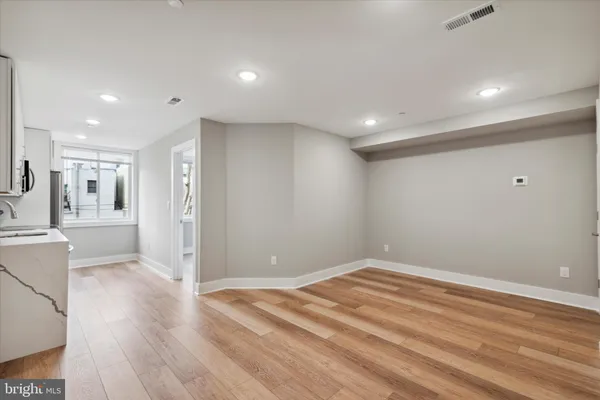 a view of empty room with wooden floor