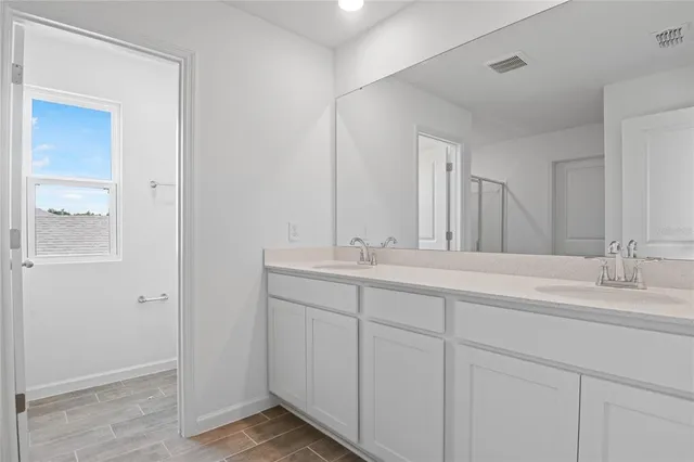 a bathroom with double sink and a mirror