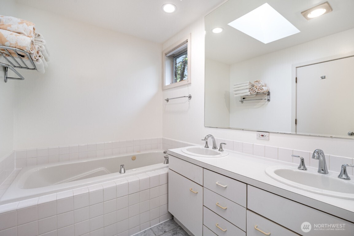 2216 19th Avenue East Seattle, WA 98112 - Photo 13 of 23 a bathroom with a tub sink double vanity and mirror