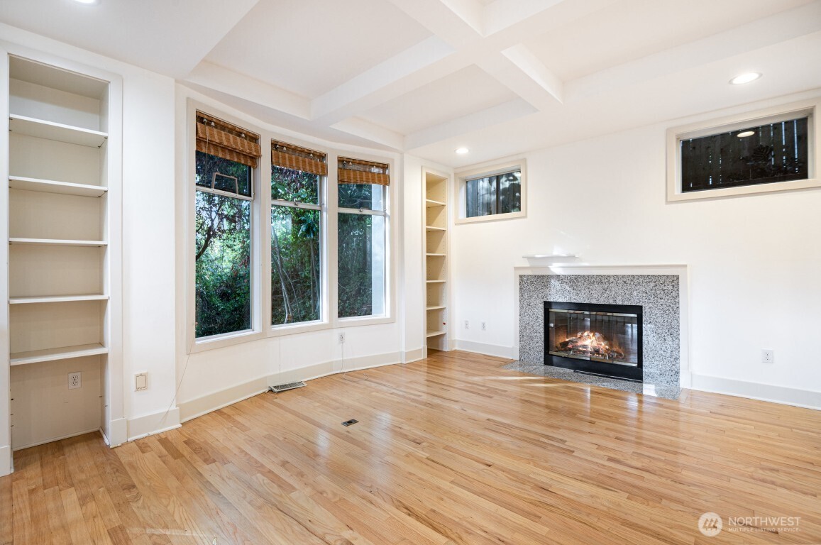 2216 19th Avenue East Seattle, WA 98112 - Photo 3 of 23 a view of an empty room with wooden floor fireplace and a window