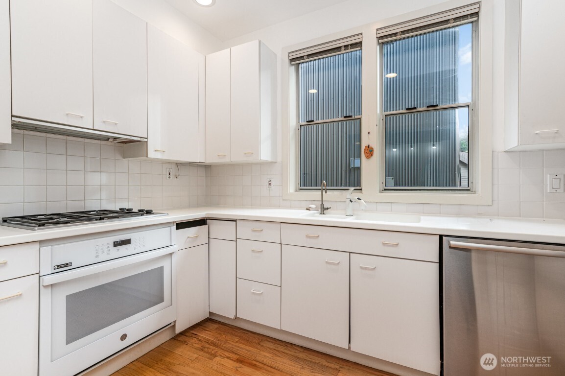 2216 19th Avenue East Seattle, WA 98112 - Photo 6 of 23 a kitchen with white cabinets and white appliances
