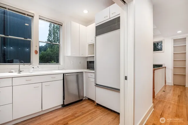 a kitchen with white cabinets and white appliances