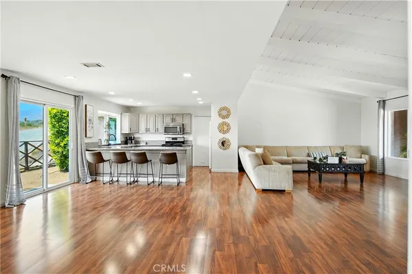 a view of a dining room and livingroom with furniture wooden floor and a rug