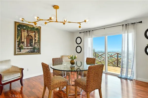 a kitchen with stainless steel appliances granite countertop a stove top oven a sink dishwasher a dining table and chairs with wooden floor