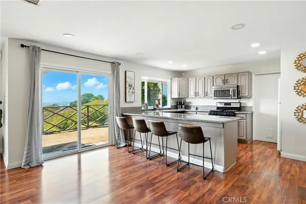 a kitchen with stainless steel appliances granite countertop a table and chairs in it