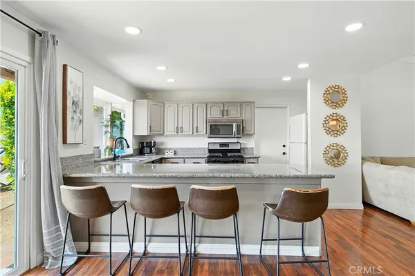 a kitchen with stainless steel appliances granite countertop a stove a sink dishwasher and a refrigerator
