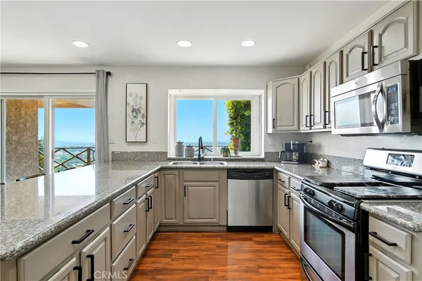 a kitchen with stainless steel appliances granite countertop a stove microwave and cabinets