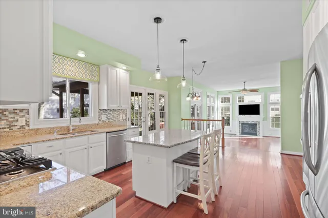 a kitchen with stainless steel appliances granite countertop a stove a sink and a wooden floors