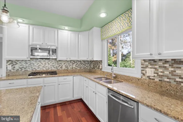 a kitchen with a sink cabinets window and appliances
