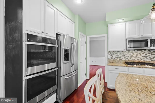 a kitchen with stainless steel appliances a stove a microwave and a refrigerator