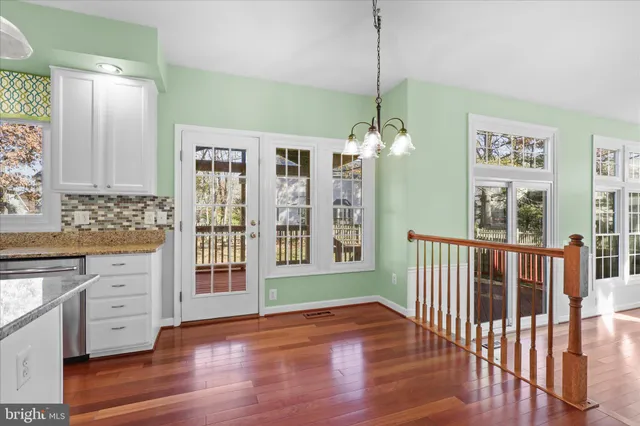 a view of a hallway with wooden floor and windows