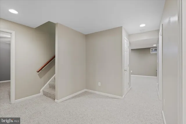 an empty room with a chandelier fan and windows
