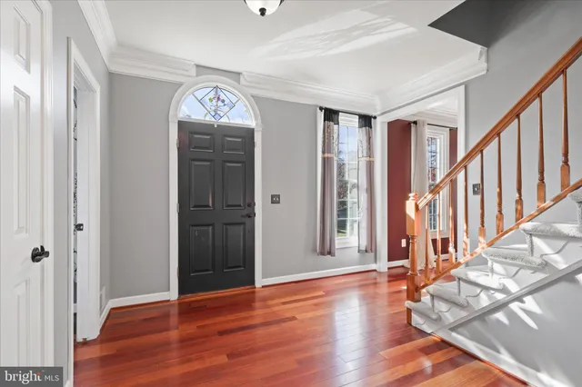 a view of a hallway with wooden floor and stairs
