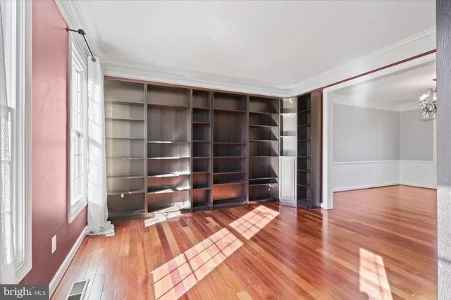 a view of empty room with wooden floor and closet