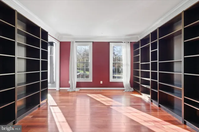 a view of empty room with wooden floor and windows