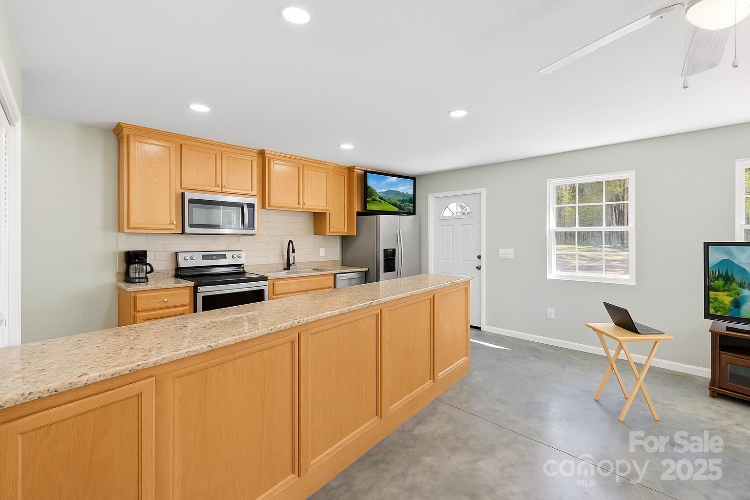 2411 Mission Road York, SC 29745 - Photo 21 of 30 a kitchen with stainless steel appliances granite countertop a sink a stove a refrigerator cabinets and living room view