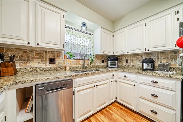 a kitchen with granite countertop white cabinets and white appliances
