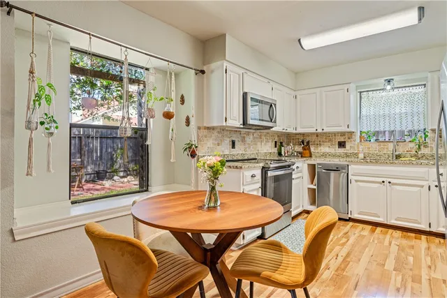 a kitchen with a table chairs sink and cabinets
