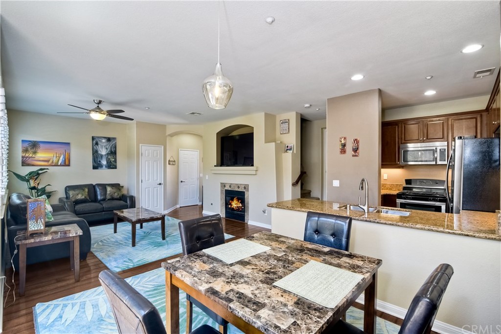 4115 Karst Road Carlsbad, CA 92010 - Photo 12 of 33 a living room with fireplace furniture and a dining table with wooden floor