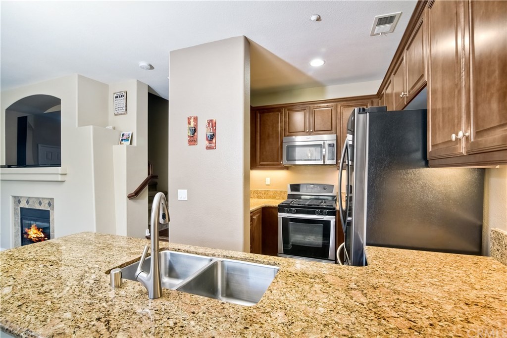 4115 Karst Road Carlsbad, CA 92010 - Photo 15 of 33 a kitchen with stainless steel appliances kitchen island granite countertop a refrigerator and a sink