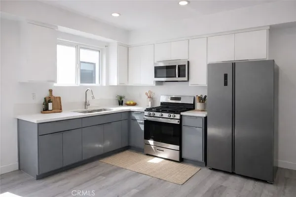 a kitchen with stainless steel appliances granite countertop a refrigerator and a sink