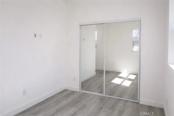 an empty room with wooden floor and door