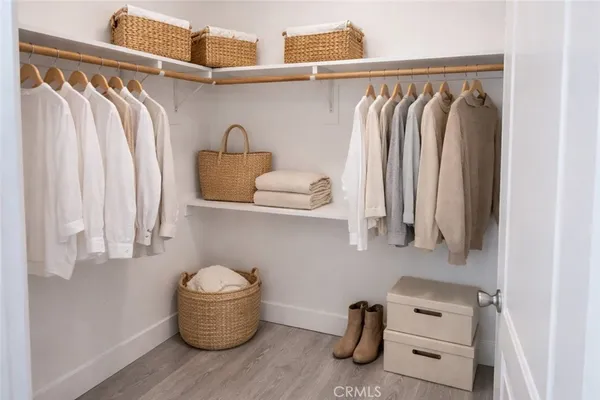 a view of walk in closet with clothes and shoes