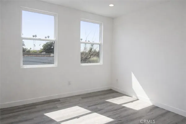 an empty room with wooden floor and window