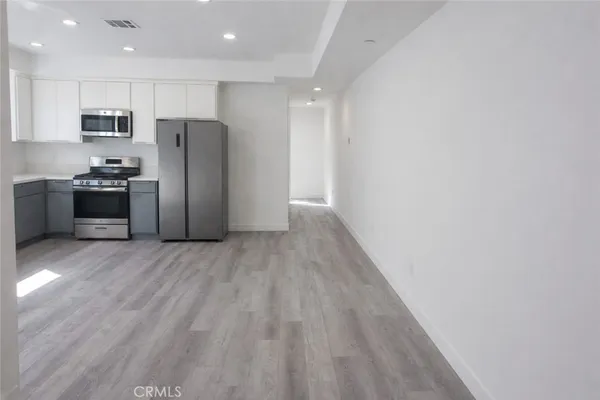 a kitchen with stainless steel appliances a refrigerator and a stove top oven