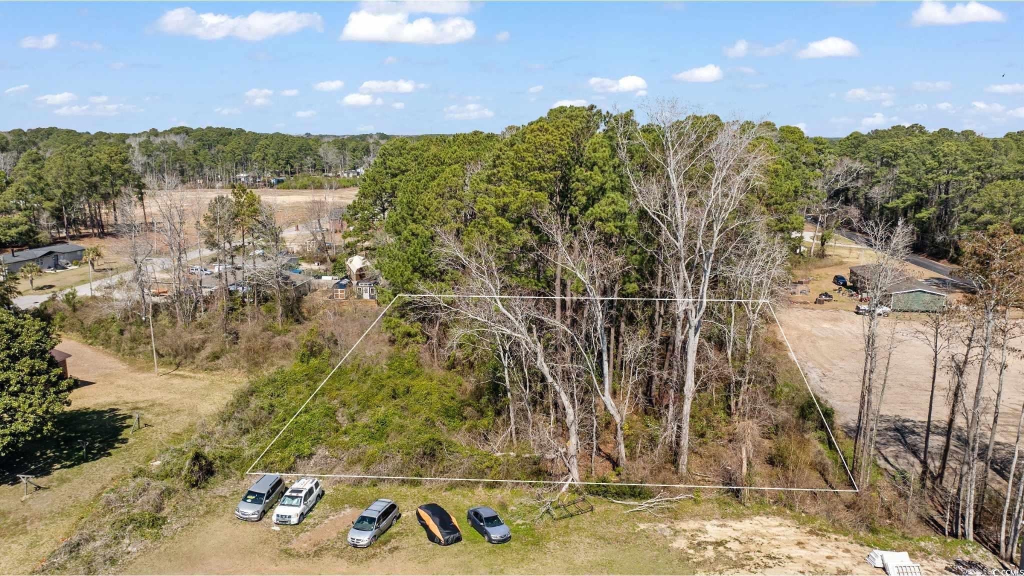 90 Adam Street Little River, SC 29566 - Photo 3 of 6 Drone / aerial view featuring a wooded view